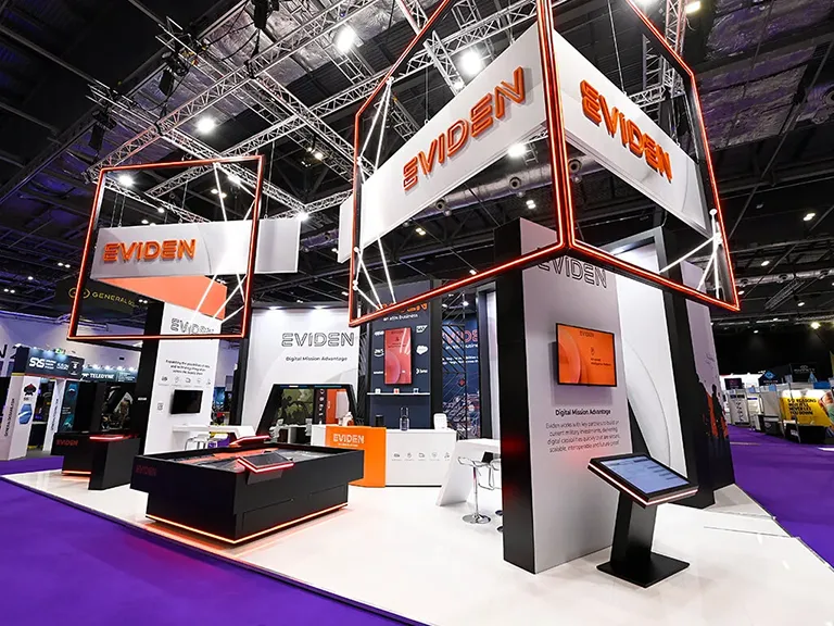 An engaging, bespoke exhibition stand for Eviden, showcasing their orange and black branding with some digital technology to showcase their services